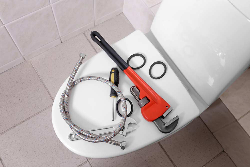 Plumber's tools on toilet at home