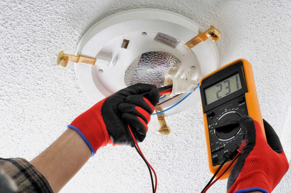 Electrician Measuring Voltage Of A Light Socket