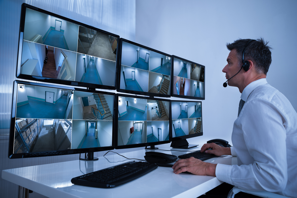 man-looking-at-monitors-security-alarms