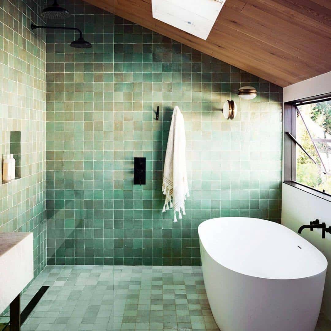 renovated bathroom with green tiling and walk in shower
