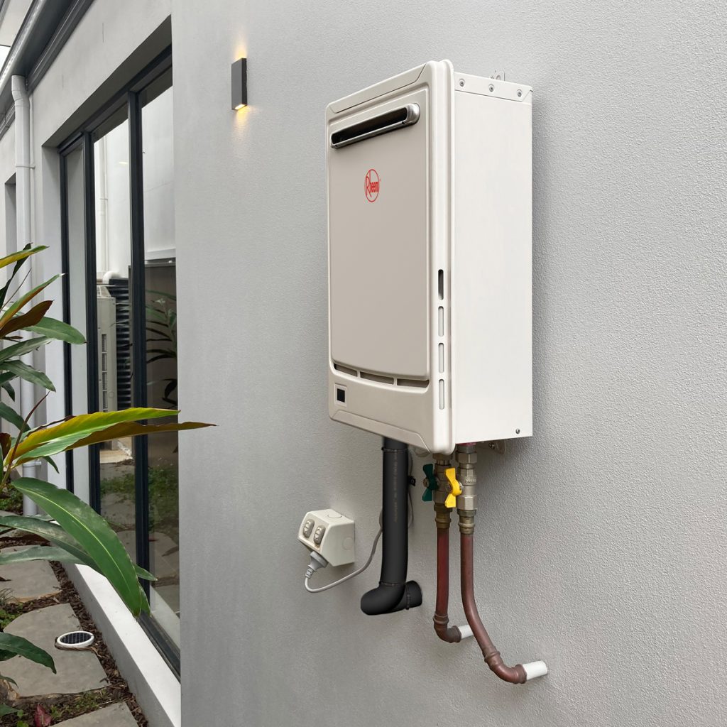 rheum gas continuous flow hot water system installed on the side of a house